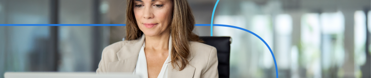 Professional woman in a business setting focused on her laptop, illustrating the process of learning how to write a medical CV