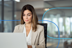 Professional woman in a business setting focused on her laptop, illustrating the process of learning how to write a medical CV