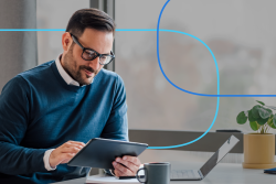 Professional man using tablet for job search tips at modern office desk with laptop and coffee mug – career planning for healthcare job seekers