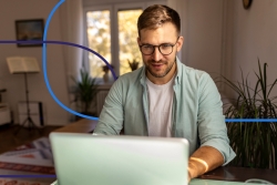 A physician working on a laptop from home, representing modern physician market trends and remote work in healthcare.