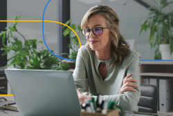 A female healthcare recruiter actively engages on a laptop in a contemporary office setting