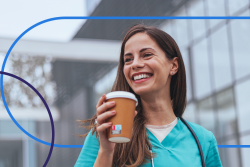 smiling CRNA enjoying a coffee break outdoors in scrubs, representing work-life balance for nurse anesthetists