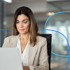 Professional woman in a business setting focused on her laptop, illustrating the process of learning how to write a medical CV