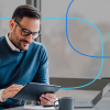 Professional man using tablet for job search tips at modern office desk with laptop and coffee mug – career planning for healthcare job seekers
