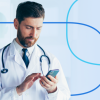 Doctor in a white coat with a stethoscope around his neck using a smartphone