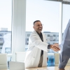 Doctor shaking hands with admin after meeting
