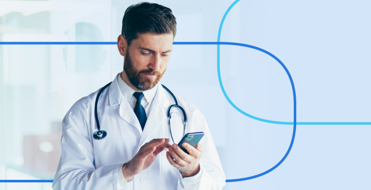 Doctor in a white coat with a stethoscope around his neck using a smartphone